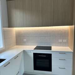 Kitchen with lit vertical splashback