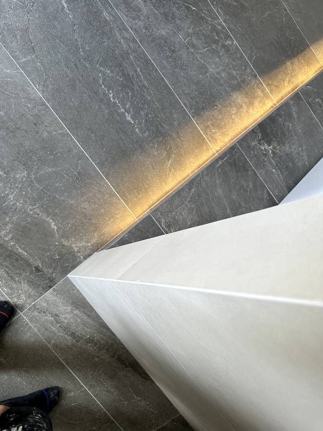 Plinth edge: A crisp tiled edge on the bath plinth, LED strip tucked underneath.